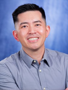 Portrait of Dr. Ethan Do smiling in a grey collared shirt.